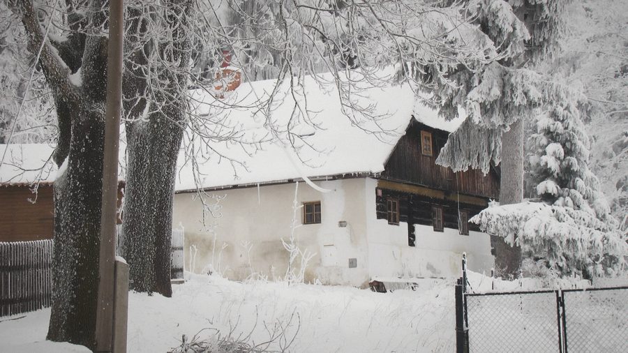 Roubenka pod sněhem za plotem